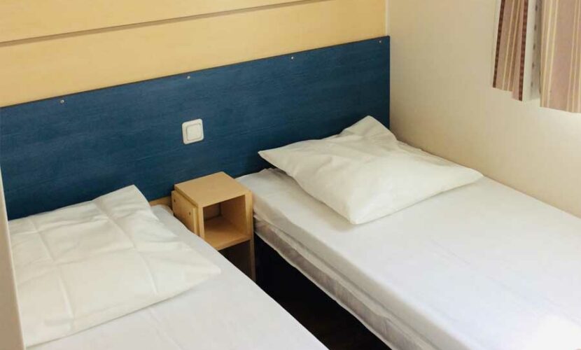 Deux lits simples dans une chambre au camping de contrexeville